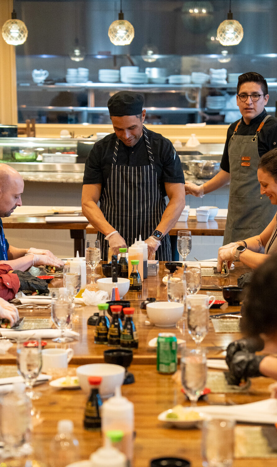 http://Corporate%20retreat%20group%20enjoying%20a%20private%20dining%20experience%20with%20chefs%20at%20an%20interactive%20restaurant%20venue